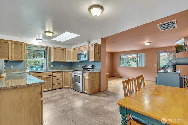 11022 SE 313th St, Auburn, WA 98092 - kitchen with appliances with stainless steel finishes, a skylight, and light stone countertops