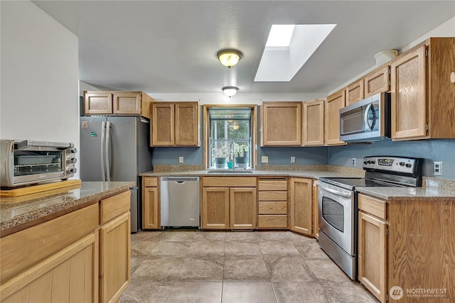 11022 SE 313th St, Auburn, WA 98092 - kitchen featuring stainless steel appliances, a skylight, and light stone counters