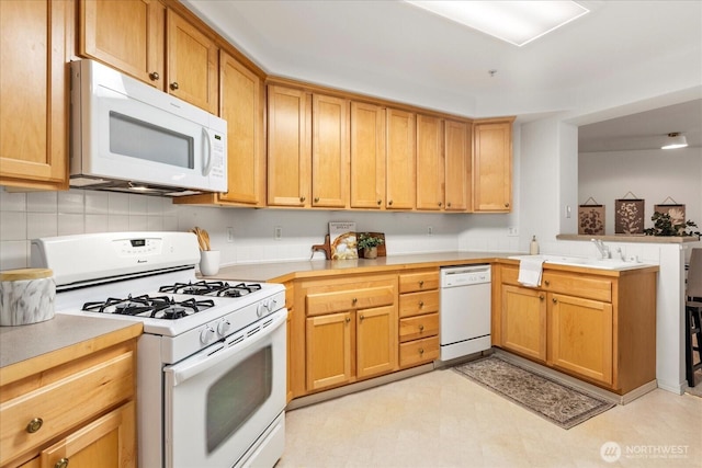 8500 Main St Unit F205, Edmonds, WA 98026 - kitchen with white appliances, a peninsula, light countertops, and tasteful backsplash