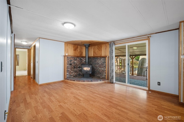 8265 Skeena Way, Blaine, WA 98230 - unfurnished living room with wood finished floors, a wood stove, and crown molding