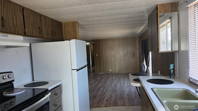 511 Leisure Cir, Aberdeen, WA 98520 - kitchen featuring electric stove, wooden walls, light countertops, under cabinet range hood, and dark wood-type flooring