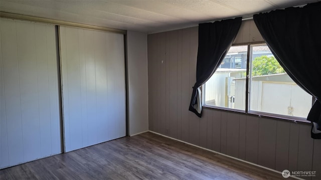 511 Leisure Cir, Aberdeen, WA 98520 - unfurnished bedroom featuring wood finished floors, wooden walls, and a closet