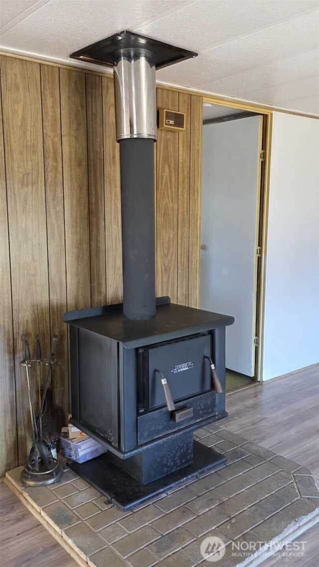 511 Leisure Cir, Aberdeen, WA 98520 - detailed view of a wood stove, wood finished floors, and wooden walls