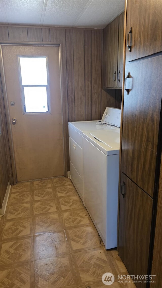511 Leisure Cir, Aberdeen, WA 98520 - laundry room featuring cabinet space, washing machine and clothes dryer, wood walls, and light flooring