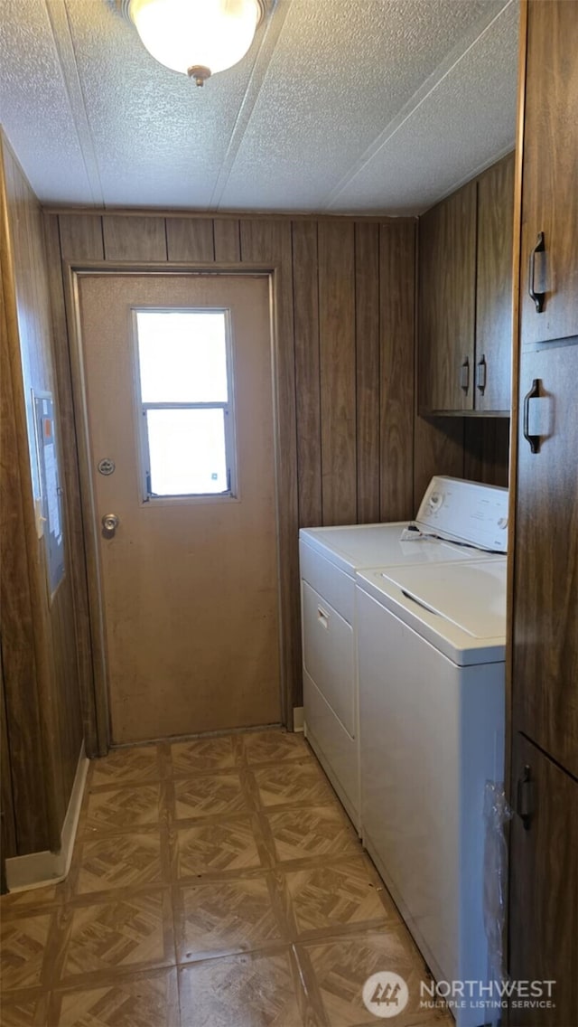 511 Leisure Cir, Aberdeen, WA 98520 - laundry room featuring washer and dryer, cabinet space, wood walls, a textured ceiling, and light floors