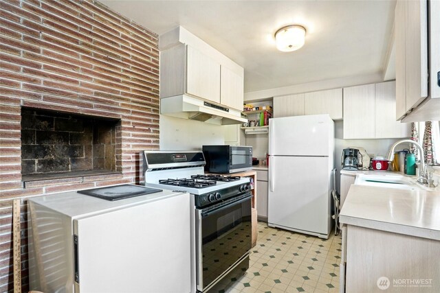 10629 NE 26th St, Bellevue, WA 98004 - kitchen featuring freestanding refrigerator, gas range oven, black microwave, under cabinet range hood, and light countertops
