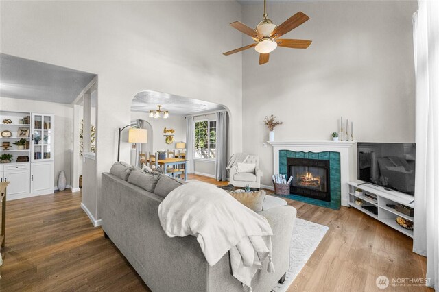 7605 38th Ct SE, Lacey, WA 98503 - living area featuring arched walkways, wood finished floors, ceiling fan, a chandelier, and a fireplace