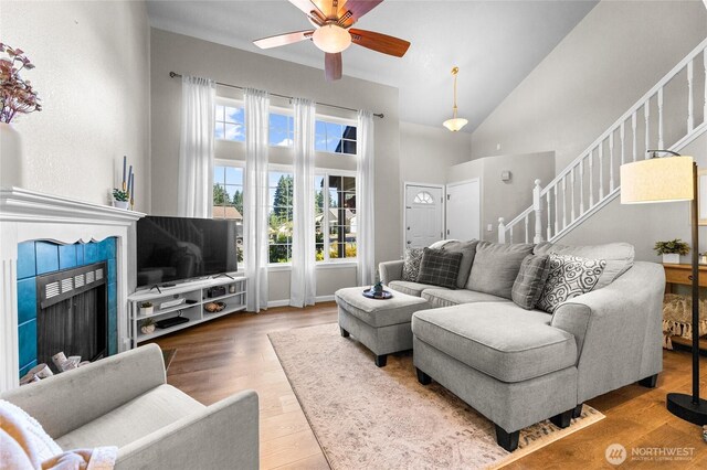 7605 38th Ct SE, Lacey, WA 98503 - living area with stairway, ceiling fan, high vaulted ceiling, wood finished floors, and a tile fireplace