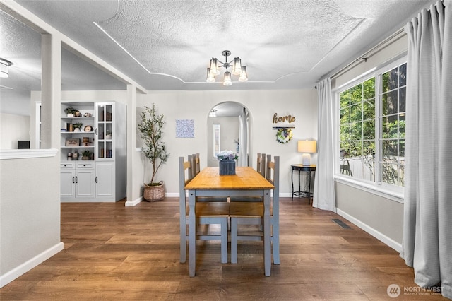 7605 38th Ct SE, Lacey, WA 98503 - dining room featuring arched walkways, a textured ceiling, wood finished floors, and a chandelier