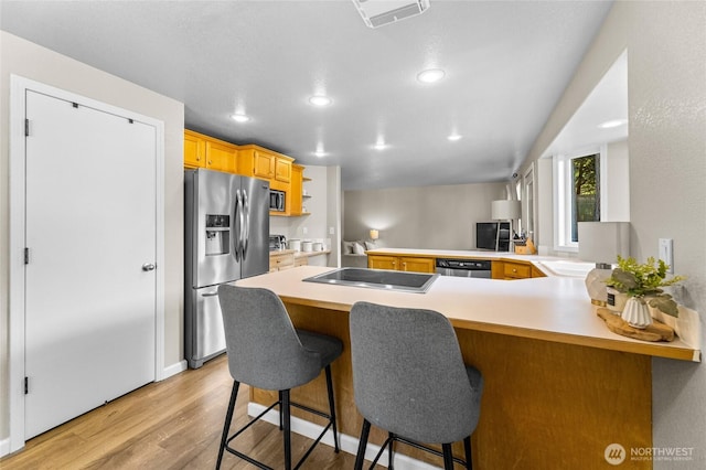 7605 38th Ct SE, Lacey, WA 98503 - kitchen with appliances with stainless steel finishes, light wood-style flooring, a peninsula, light countertops, and recessed lighting