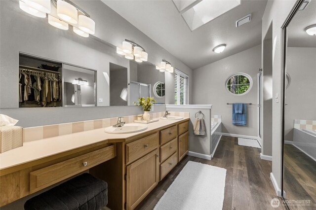 7605 38th Ct SE, Lacey, WA 98503 - full bathroom featuring double vanity, lofted ceiling, a garden tub, wood finished floors, and a shower stall