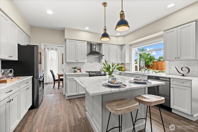 4212 145th Pl SE, Snohomish, WA 98296 - kitchen with appliances with stainless steel finishes, wall chimney range hood, a kitchen island, tasteful backsplash, and dark wood-style floors