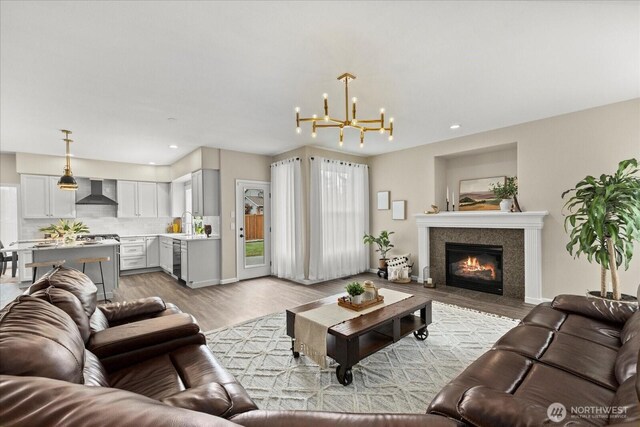 4212 145th Pl SE, Snohomish, WA 98296 - living area with a chandelier, light wood-style flooring, a tiled fireplace, and recessed lighting