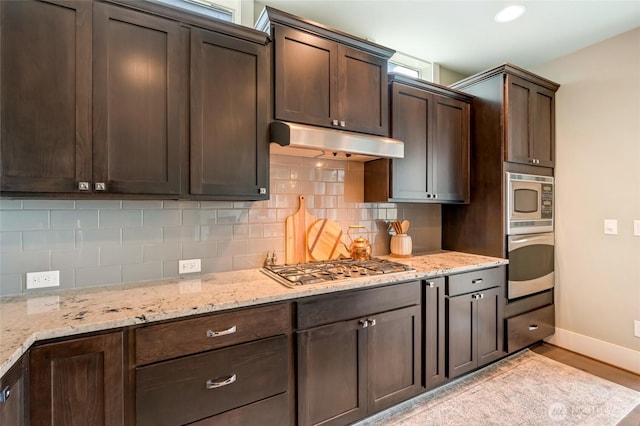 619 Graham Ave NE, Renton, WA 98059 - kitchen featuring appliances with stainless steel finishes, under cabinet range hood, dark brown cabinets, and decorative backsplash