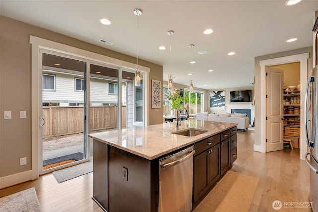 619 Graham Ave NE, Renton, WA 98059 - kitchen with appliances with stainless steel finishes, open floor plan, light wood finished floors, a center island with sink, and recessed lighting