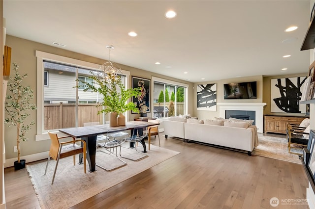 619 Graham Ave NE, Renton, WA 98059 - dining space featuring light wood-style floors, recessed lighting, a chandelier, and a tile fireplace
