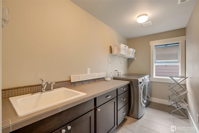 619 Graham Ave NE, Renton, WA 98059 - laundry room featuring washer and dryer, cabinet space, and light tile patterned floors