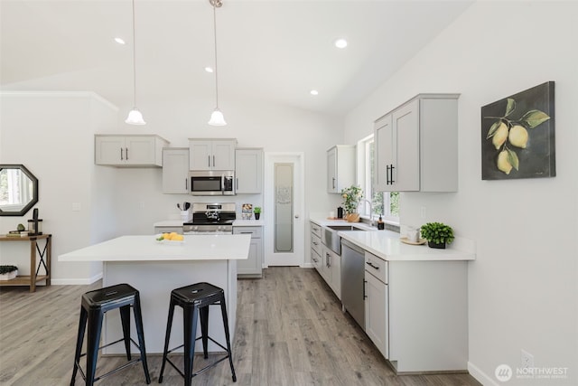 13540 Carney Lake Rd SW, Port Orchard, WA 98367 - kitchen with appliances with stainless steel finishes, lofted ceiling, a kitchen bar, light countertops, and light wood-style flooring