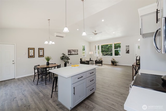 13540 Carney Lake Rd SW, Port Orchard, WA 98367 - kitchen with a kitchen breakfast bar, wood finished floors, light countertops, hanging light fixtures, and lofted ceiling