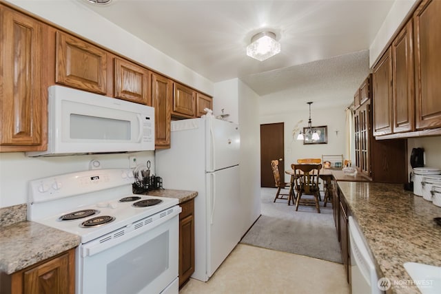 30026 5th Ave SW, Federal Way, WA 98023 - kitchen featuring white appliances, brown cabinetry, a chandelier, decorative light fixtures, and light stone countertops