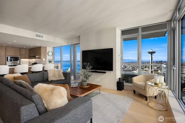 583 Battery St Unit 3802, Seattle, WA 98121 - living area featuring light wood-style flooring and a wall of windows