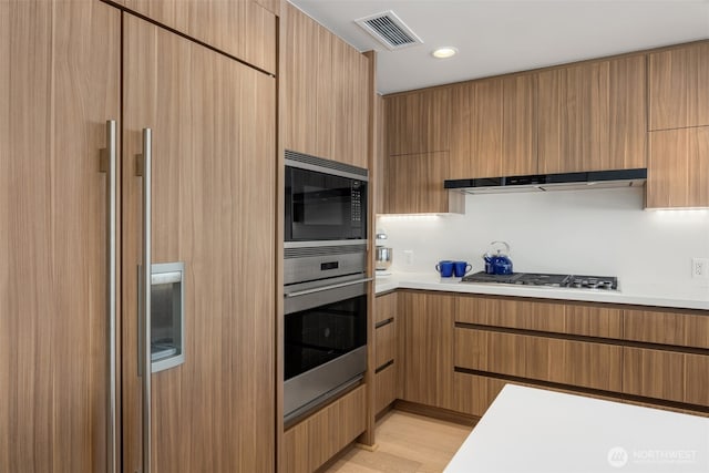 583 Battery St Unit 3802, Seattle, WA 98121 - kitchen featuring built in appliances, light countertops, modern cabinets, light wood finished floors, and recessed lighting