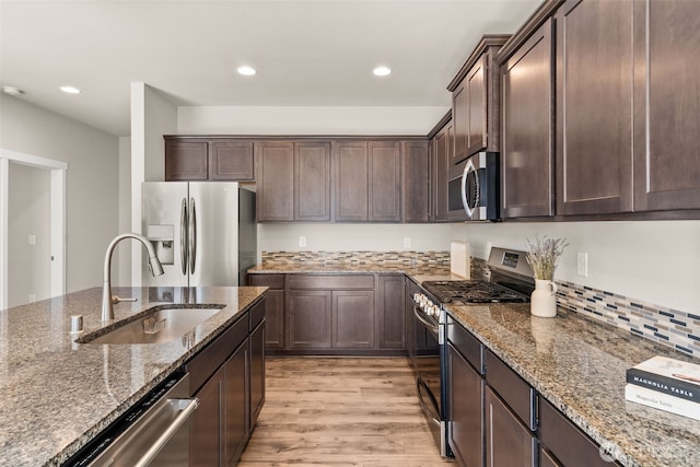 2846 Anna St NE, Lacey, WA 98516 - kitchen featuring stainless steel appliances, light wood-type flooring, dark brown cabinets, dark stone countertops, and recessed lighting