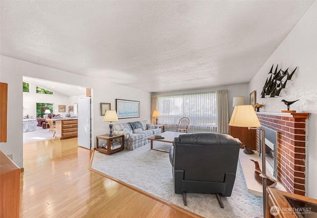 527 Fern Rd, Bellingham, WA 98225 - living room with a brick fireplace, light wood-type flooring, and a textured ceiling