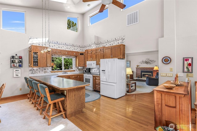 527 Fern Rd, Bellingham, WA 98225 - kitchen with white appliances, a towering ceiling, ceiling fan, light wood-style flooring, and a peninsula