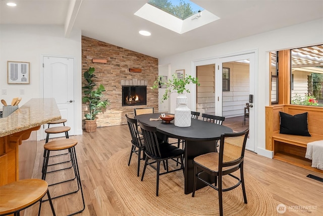 16223 NE 26th St, Bellevue, WA 98008 - dining space featuring light wood-type flooring, a skylight, and a stone fireplace