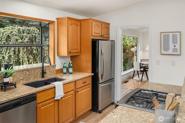 16223 NE 26th St, Bellevue, WA 98008 - kitchen with stainless steel appliances, light wood-style floors, light stone countertops, and brown cabinetry