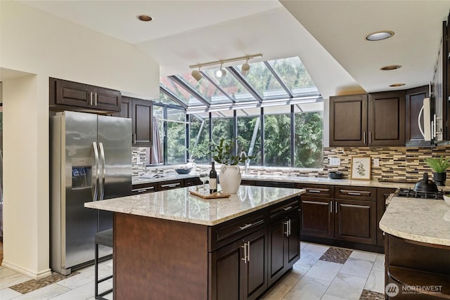 17726 NE 26th St, Redmond, WA 98052 - kitchen with stainless steel fridge, tasteful backsplash, light stone countertops, plenty of natural light, and recessed lighting