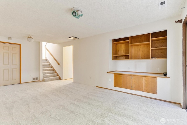 17726 NE 26th St, Redmond, WA 98052 - unfurnished living room featuring light carpet, a textured ceiling, and stairs