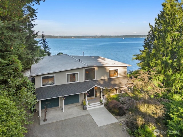 10212 SW 127th St, Vashon, WA 98070 - view of front facade with covered porch, a water view, driveway, a garage, and a shingled roof