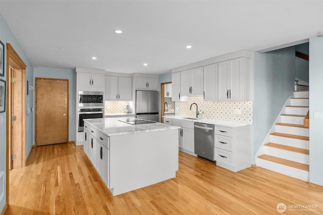 10212 SW 127th St, Vashon, WA 98070 - kitchen with appliances with stainless steel finishes, light wood-style floors, backsplash, a kitchen island, and recessed lighting