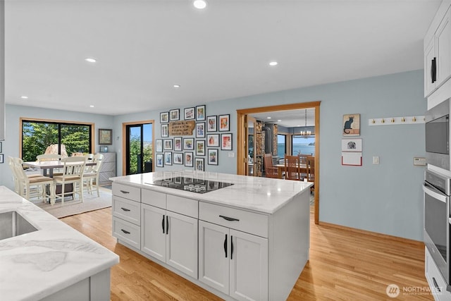 10212 SW 127th St, Vashon, WA 98070 - kitchen featuring stainless steel appliances, white cabinetry, light stone countertops, light wood-type flooring, and a chandelier