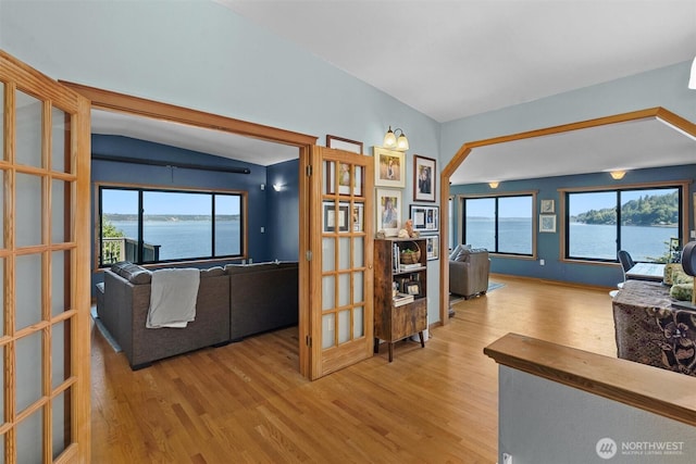 10212 SW 127th St, Vashon, WA 98070 - living area with wood finished floors, plenty of natural light, french doors, vaulted ceiling, and a water view