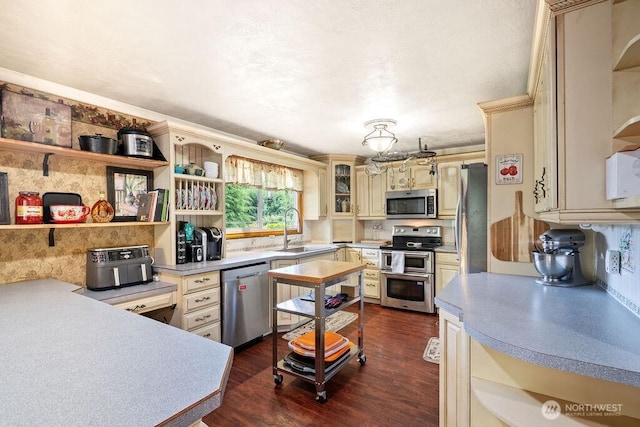 1315 Thomas St, Aberdeen, WA 98520 - kitchen featuring appliances with stainless steel finishes, cream cabinetry, open shelves, and dark wood-style flooring