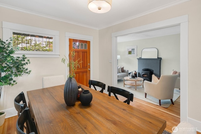 5041 Baker Ave NW, Seattle, WA 98107 - dining space featuring ornamental molding, plenty of natural light, a wood stove, and wood finished floors