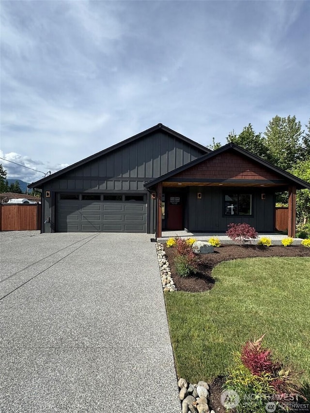 404 Trail St, Darrington, WA 98241 - view of front facade with board and batten siding, a garage, asphalt driveway, and a front yard