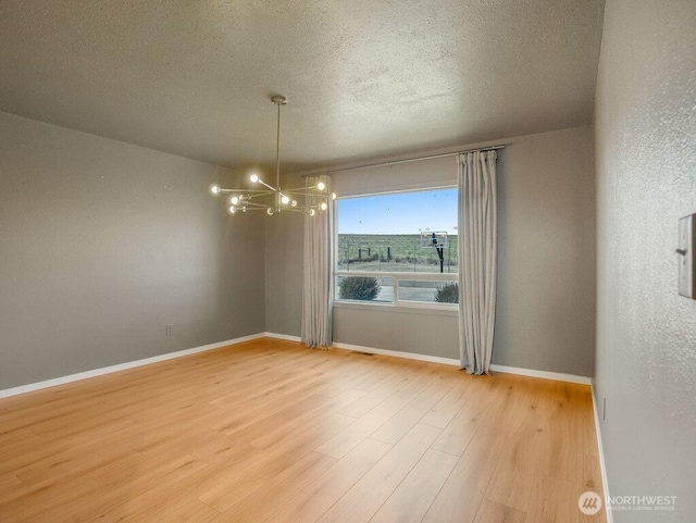 2 W Johnson Ln, Lind, WA 99341 - spare room with a chandelier, light wood-style flooring, and a textured ceiling