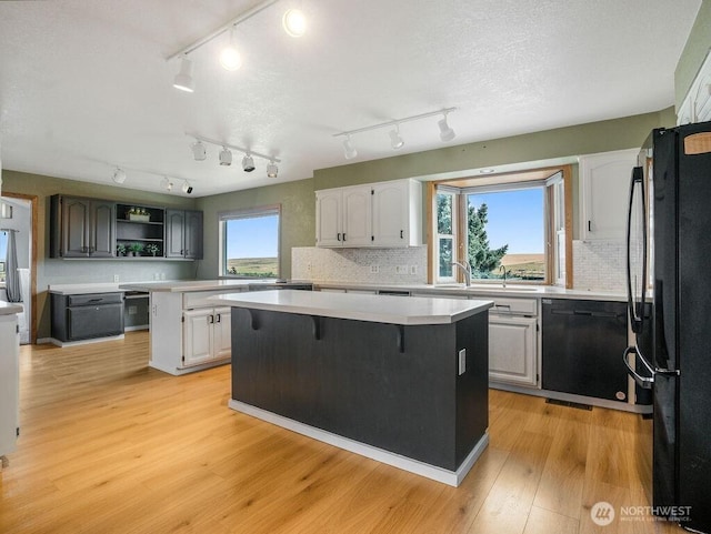 2 W Johnson Ln, Lind, WA 99341 - kitchen with black appliances, a center island, light countertops, open shelves, and light wood-style flooring