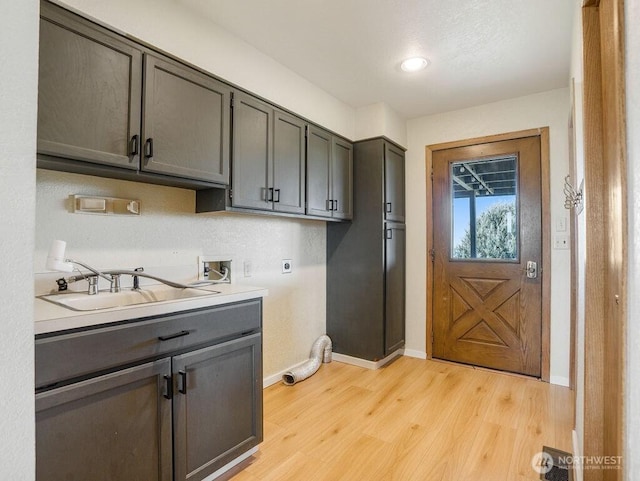 2 W Johnson Ln, Lind, WA 99341 - washroom featuring electric dryer hookup, cabinet space, washer hookup, and light wood-style flooring