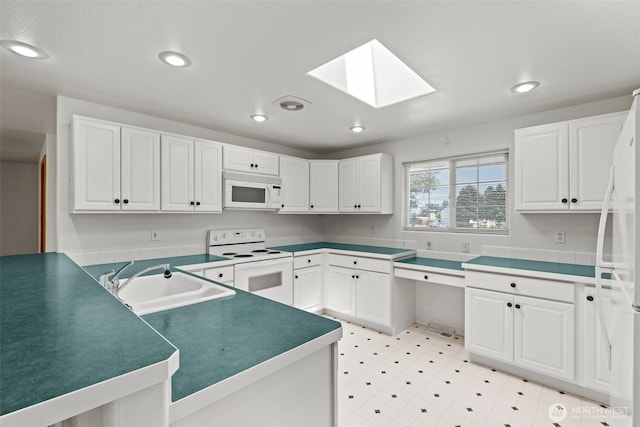 19214 Lakeview Dr, Soap Lake, WA 98851 - kitchen featuring white appliances, a skylight, recessed lighting, white cabinets, and light flooring