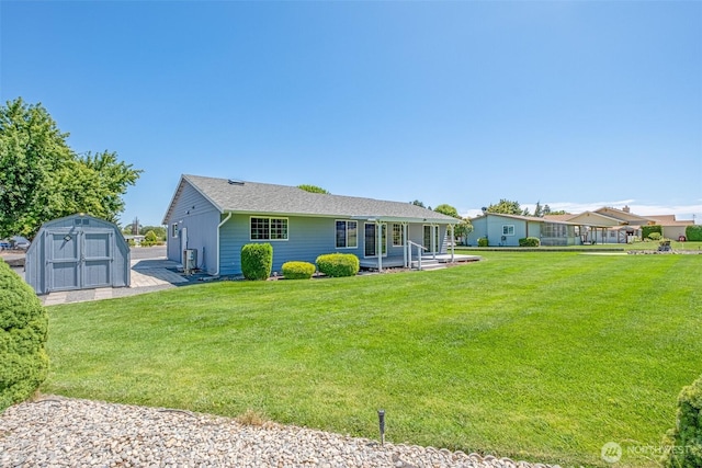 19214 Lakeview Dr, Soap Lake, WA 98851 - back of property with a storage shed, a lawn, and a shingled roof