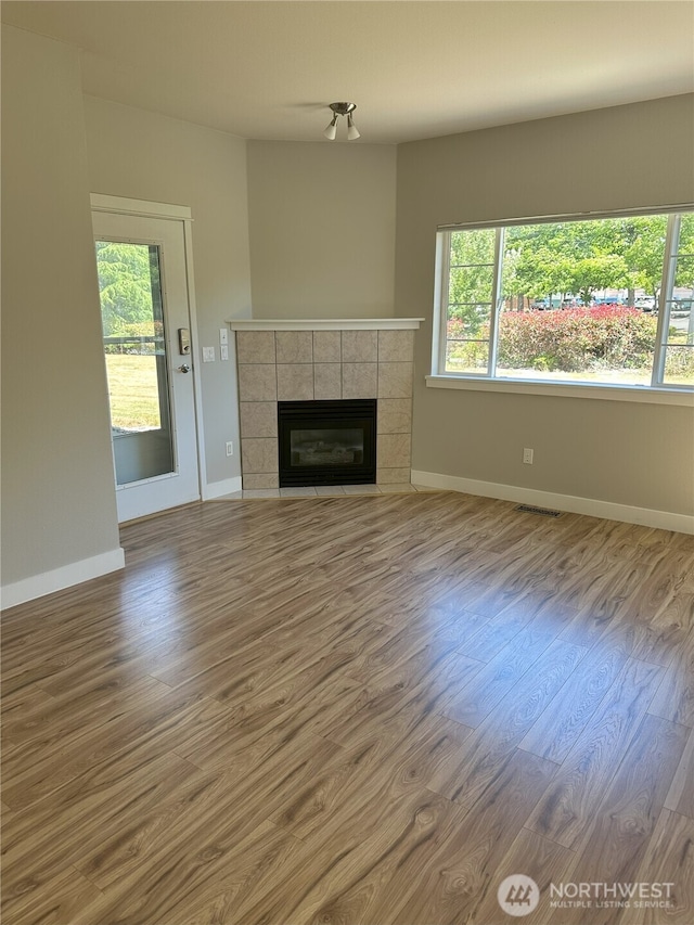 515 W Kellogg Rd, Bellingham, WA 98226 - unfurnished living room with wood finished floors, healthy amount of natural light, and a tile fireplace