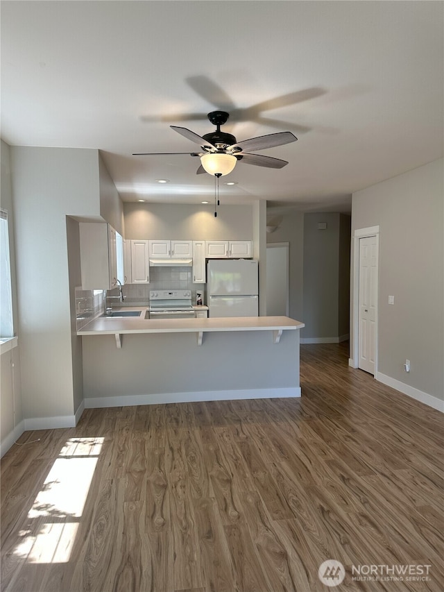 515 W Kellogg Rd, Bellingham, WA 98226 - kitchen with white appliances, wood finished floors, light countertops, and a peninsula