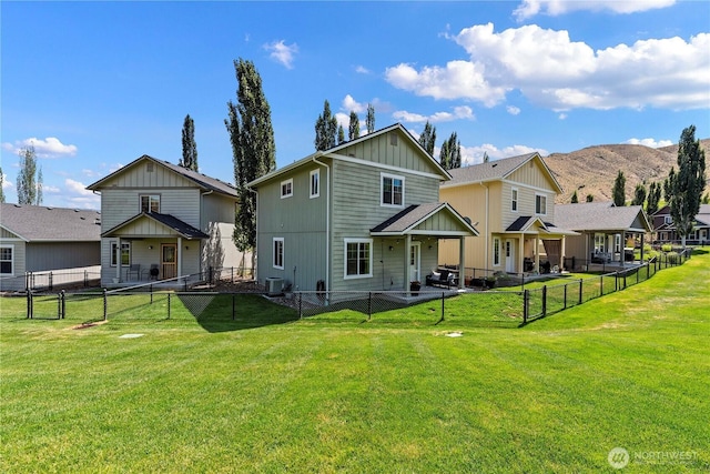 300 Saddlehorn Ln, Wenatchee, WA 98801 - rear view of house with board and batten siding, a fenced backyard, and a mountain view