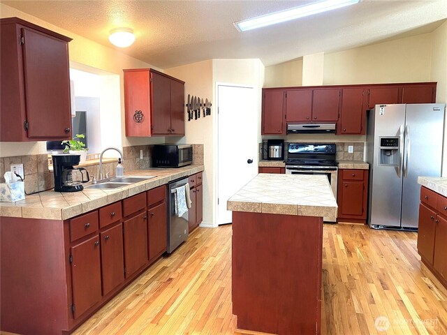 4820 NE 7.5 Rd, Moses Lake, WA 98837 - kitchen featuring appliances with stainless steel finishes, under cabinet range hood, light wood finished floors, and tasteful backsplash