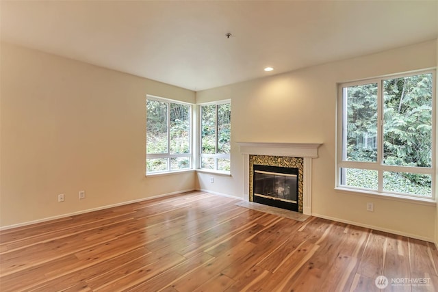 3924 243rd Pl SE Unit G204, Bothell, WA 98201 - unfurnished living room featuring hardwood / wood-style flooring, a premium fireplace, plenty of natural light, and recessed lighting